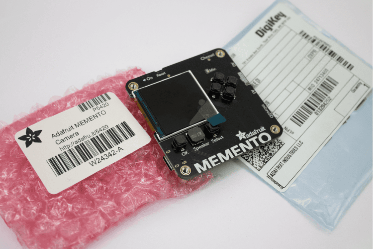 Adafruit MEMENTO camera board unboxing showing dev board with display and camera
