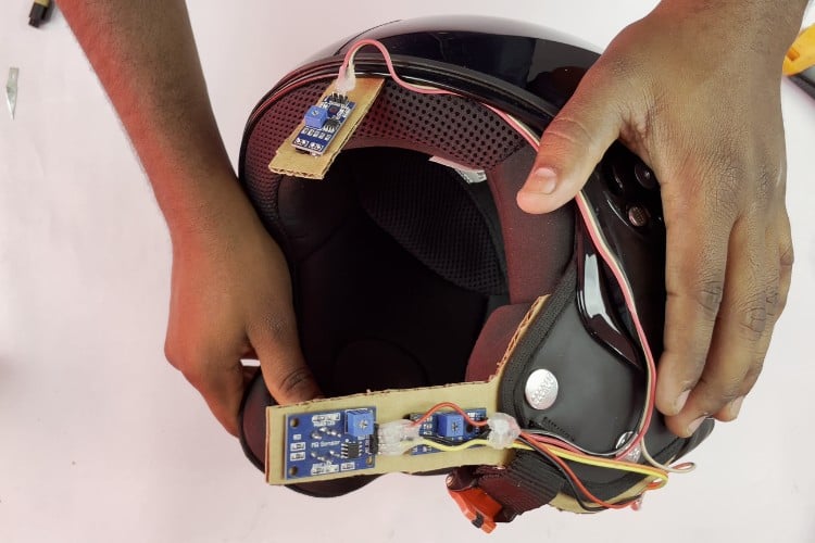 Physical assembly showing IR sensors and MQ-3 alcohol sensor mounted inside helmet with connecting wires for smart helmet project using Arduino