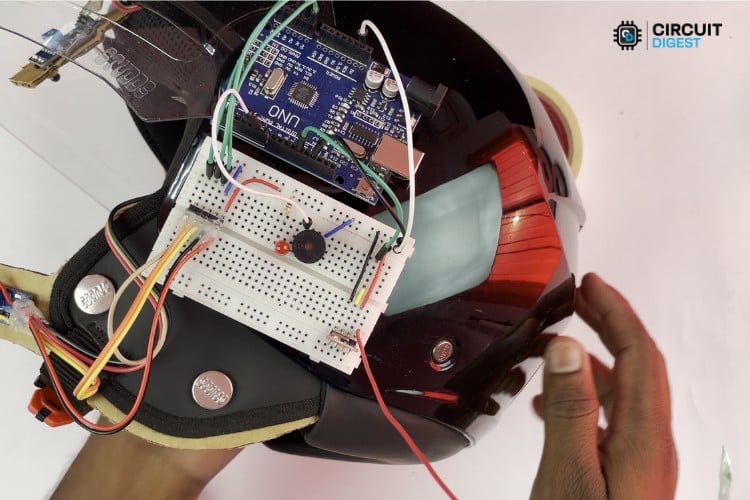 Breadboard circuit assembly showing Arduino UNO connected to RF transmitter, LED, buzzer with current limiting resistor for smart helmet project using Arduino